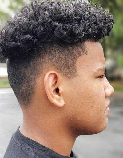Boy with fade haircut by New Dimensions School of Hair Design