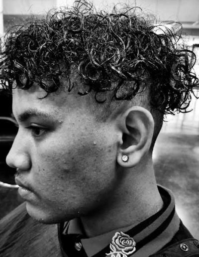 Male with curly hair cut by New Dimensions School of Hair Design